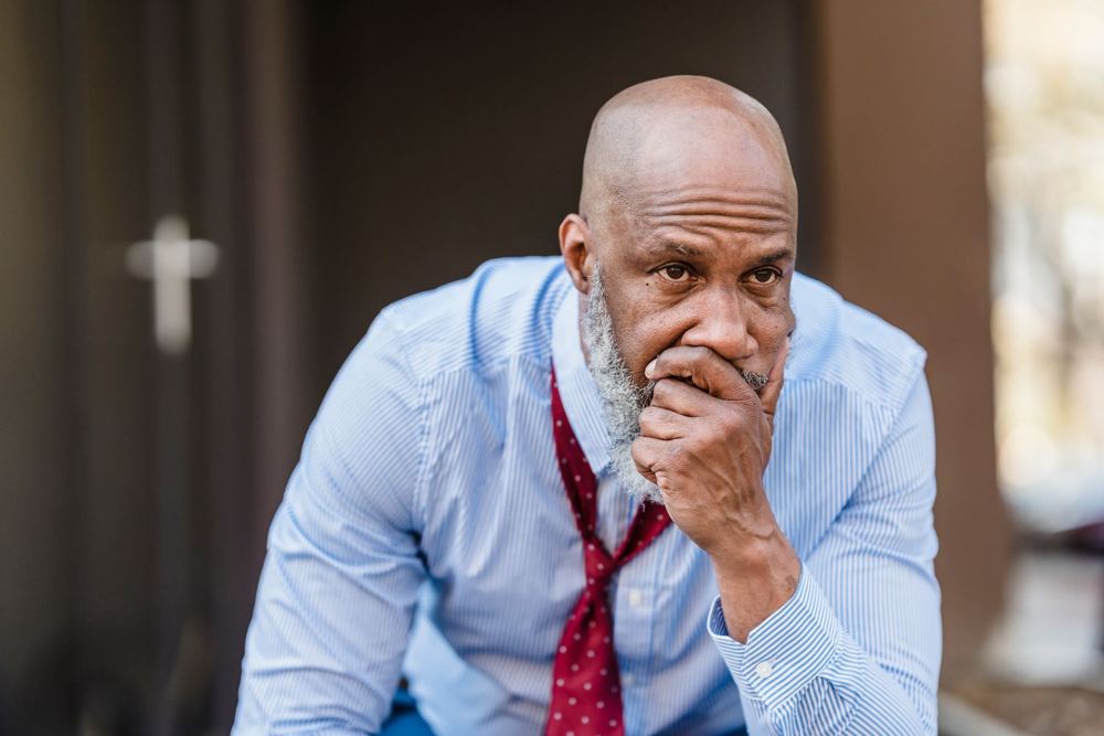 Worried older man with his hand over his mouth