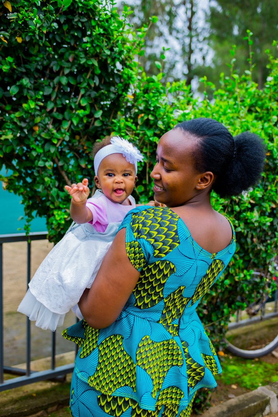 Mother holding her smiling baby girl outdoors